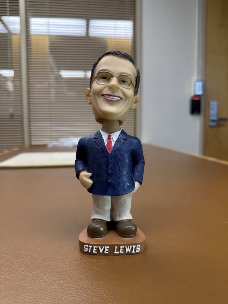 Photo of a bobblehead of former Carleton College president Steve Lewis from about 2002.